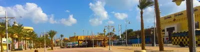 a city street with palm trees and a bus at Solider Dali in Hurghada