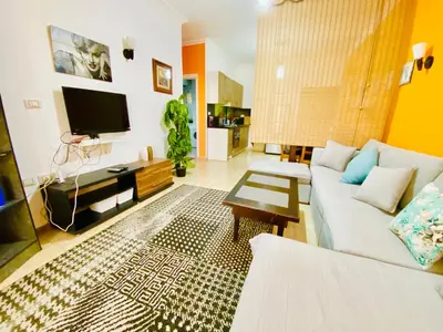 a living room with a white couch and a tv at Solider Dali in Hurghada