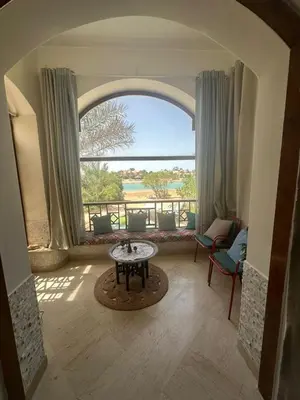 a living room with a large window and a table at chalet in nubian villas , behind Rihanna hotel in Hurghada