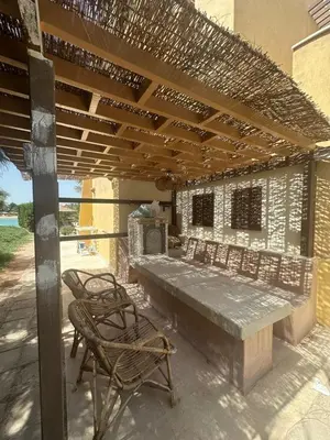 a patio with a table and chairs under a pergola at chalet in nubian villas , behind Rihanna hotel in Hurghada