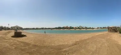 a beach with a person standing in the water at chalet in nubian villas , behind Rihanna hotel in Hurghada