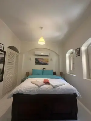 a bedroom with a large bed with blue pillows at chalet in nubian villas , behind Rihanna hotel in Hurghada