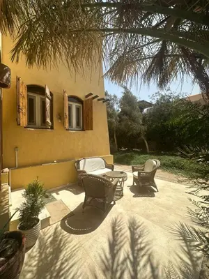 a patio with chairs and a table and a building at chalet in nubian villas , behind Rihanna hotel in Hurghada
