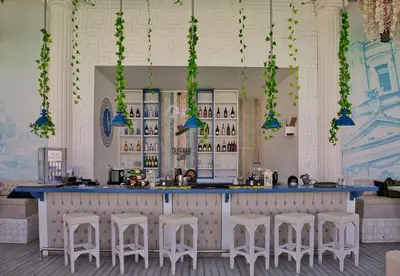 a bar with white stools and a blue counter at Arena Beach Resort & premium suits in Hurghada