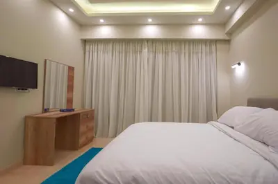 a bedroom with a bed and a flat screen tv at Arena Beach Resort & premium suits in Hurghada