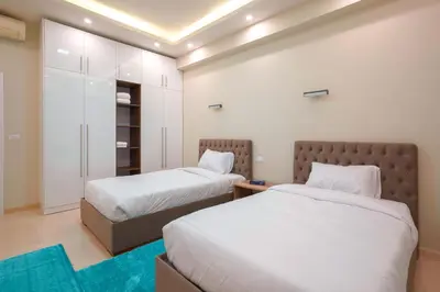 a bedroom with two beds and a closet at Arena Beach Resort & premium suits in Hurghada