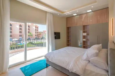 a bedroom with a large bed and a large window at Arena Beach Resort & premium suits in Hurghada