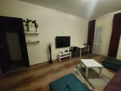 a living room with a couch and a tv at Florenza Khamsin 1 bedroom apartment with swimming pool view in Hurghada
