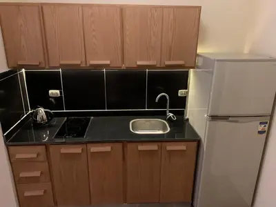 a small kitchen with a sink and a refrigerator at Florenza Khamsin 1 bedroom apartment with swimming pool view in Hurghada