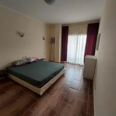 a bedroom with a bed and a wooden floor at Florenza Khamsin 1 bedroom apartment with swimming pool view in Hurghada