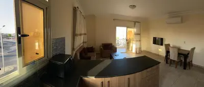 a living room with a kitchen and a dining room at Bahga Palace 4 Residential Apartments in Hurghada