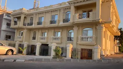 a large yellow building with balconies on a street at Bahga Palace 4 Residential Apartments in Hurghada