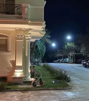 two people and two dogs sitting next to a building at Bahga Palace 5 Residential Apartments in Hurghada