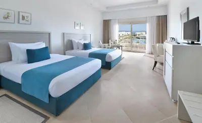 a hotel room with two beds and a television at JAZ Soma Beach in Hurghada