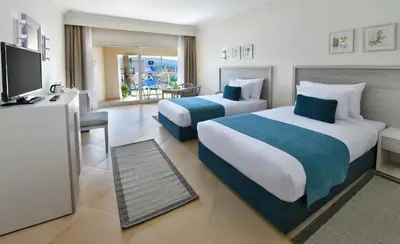a hotel room with two beds and a television at JAZ Soma Beach in Hurghada