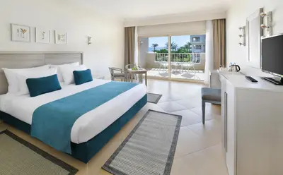 a hotel room with a large bed and a desk at JAZ Soma Beach in Hurghada