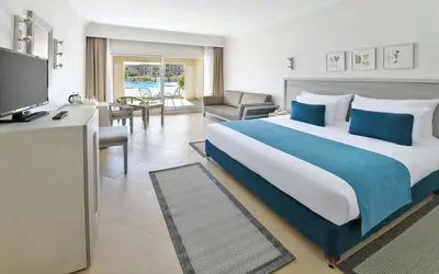 a hotel room with a large bed and a television at JAZ Soma Beach in Hurghada