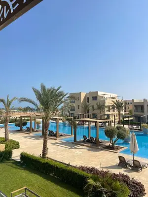 a resort with a pool and palm trees and buildings at Mangroovy Residence El Gouna - Grovin in Hurghada