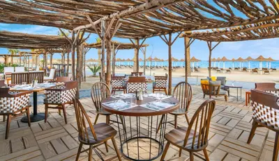 a restaurant on the beach with tables and chairs at JAZ Costa Mares- Adults Friendly 16 Years Plus in Marsa Alam City