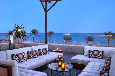 a living room with white couches and a view of the ocean at JAZ Costa Mares- Adults Friendly 16 Years Plus in Marsa Alam City