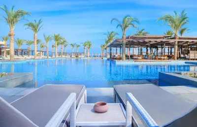 a swimming pool with palm trees and a resort at JAZ Costa Mares- Adults Friendly 16 Years Plus in Marsa Alam City