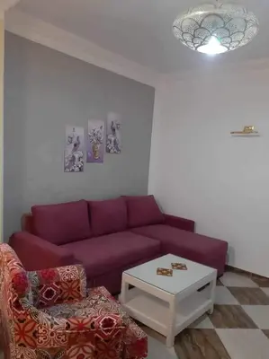 a living room with a purple couch and a coffee table at apartman Sheraton plaza 419 in Hurghada