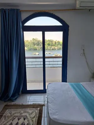 a bedroom with a window with a view of a river at NOBATiA Guest House in Aswan