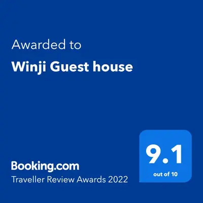 a blue screen with the text awarded to win ninth guest house at Winji Guest house in Aswan