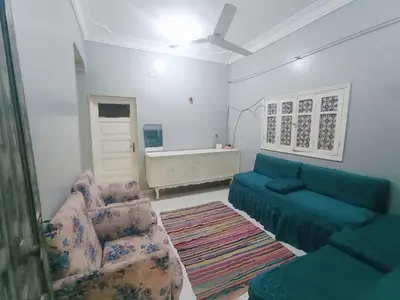 a living room with a blue couch and a chair at Winji Guest house in Aswan