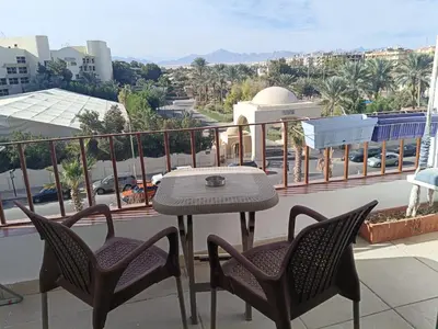 a table and chairs on a balcony with a view of a city at Studio Lotus compound near Touristic Mamsha in Hurghada