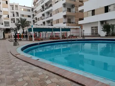 a swimming pool in front of a apartment building at Studio Lotus compound near Touristic Mamsha in Hurghada