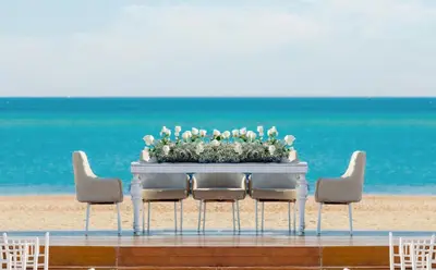 a table with a flower arrangement on the beach at Steigenberger Resort Ras Soma in Hurghada