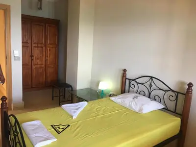 a bedroom with a bed with yellow sheets and a glass table at Coral Paradise Villa in Safaga