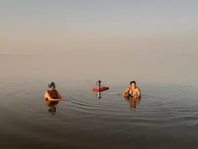 two people are sitting in the water at Coral Paradise Villa in Safaga