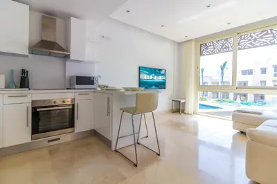 a kitchen with a counter and a chair in a room at Ollystays Mangroovy Seaview 1BR Beach and Pool Free access in Hurghada