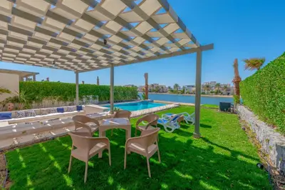 a patio with a table and chairs and a swimming pool at Joubal 3BR Villa Private Pool next to Marina in Hurghada