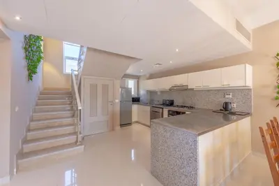 a kitchen with white cabinets and stairs in a house at Joubal 3BR Villa Private Pool next to Marina in Hurghada