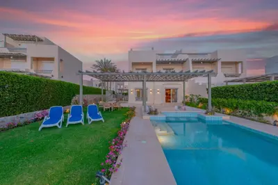 a villa with a swimming pool and two blue chairs at Joubal 3BR Villa Private Pool next to Marina in Hurghada