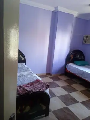 two beds in a room with purple walls at IKEA Flats in Hurghada
