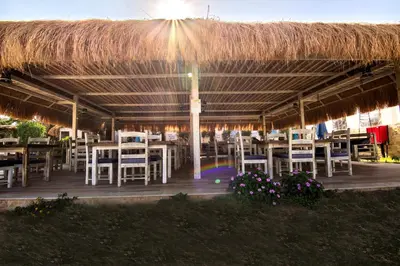 a restaurant with tables and chairs and a straw roof at AJIRA Boutique Hotel Hurghada Marina in Hurghada