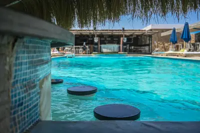 a swimming pool with blue water and some umbrellas at AJIRA Boutique Hotel Hurghada Marina in Hurghada