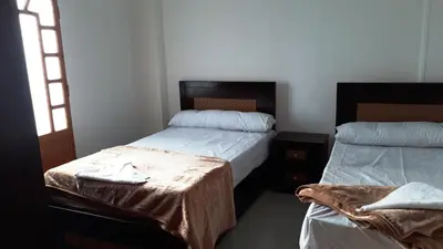 a bedroom with two beds and a table in it at Hofni Palace Nile Niew in Luxor
