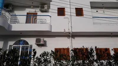 a white building with a balcony and a window at Hofni Palace Nile Niew in Luxor