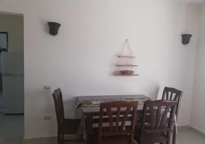 a dining room table with chairs and a sailboat on the wall at Chalet at Stella Makadi Beach in Hurghada