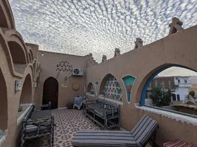 an outdoor patio with chairs and a cloudy sky at Scorpion House Luxor in Luxor