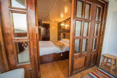a small room with a bed and a room with a door at Dahabiya ECO Queen Cleopatra in Esna