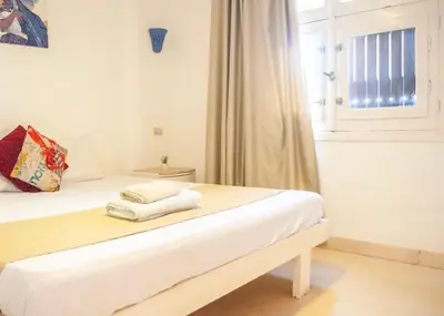 a white bedroom with a bed with towels on it at El Gouna 1 bedroom apartment in West Golf Y12 in Hurghada