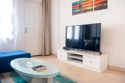 a living room with a flat screen tv and a table at El Gouna 1 bedroom apartment in West Golf Y12 in Hurghada