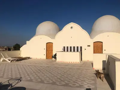 a large white building with two domes on it at Elsanosy Family Guest House - Luxor in Luxor