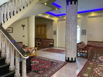 a lobby with stairs and a column with rugs at Elsanosy Family Guest House - Luxor in Luxor